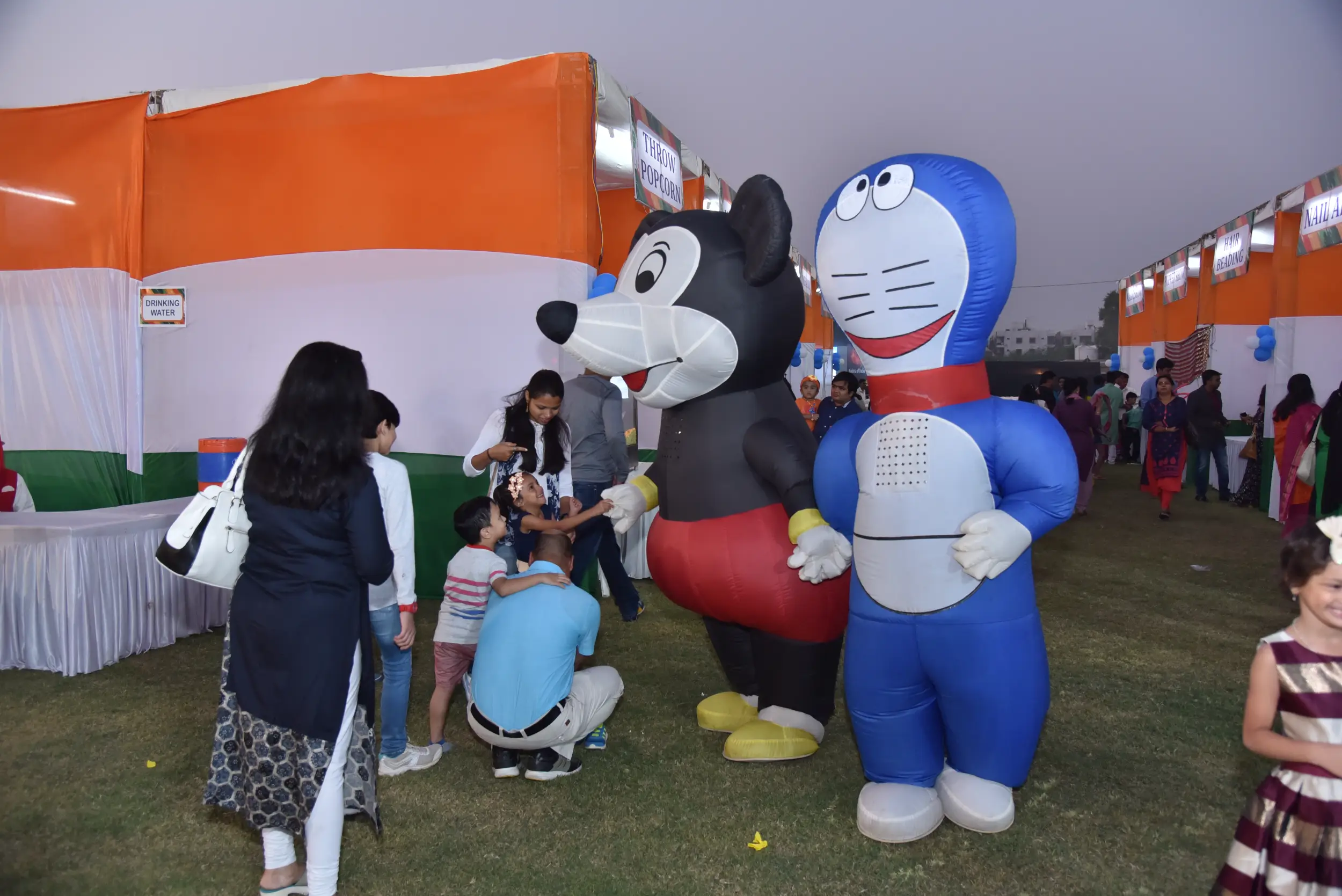 Group of men posing with large cartoon character inflatable figures at night outdoors